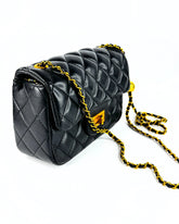 Sac matelassé noir avec chaîne entrelacée et fermoir doré