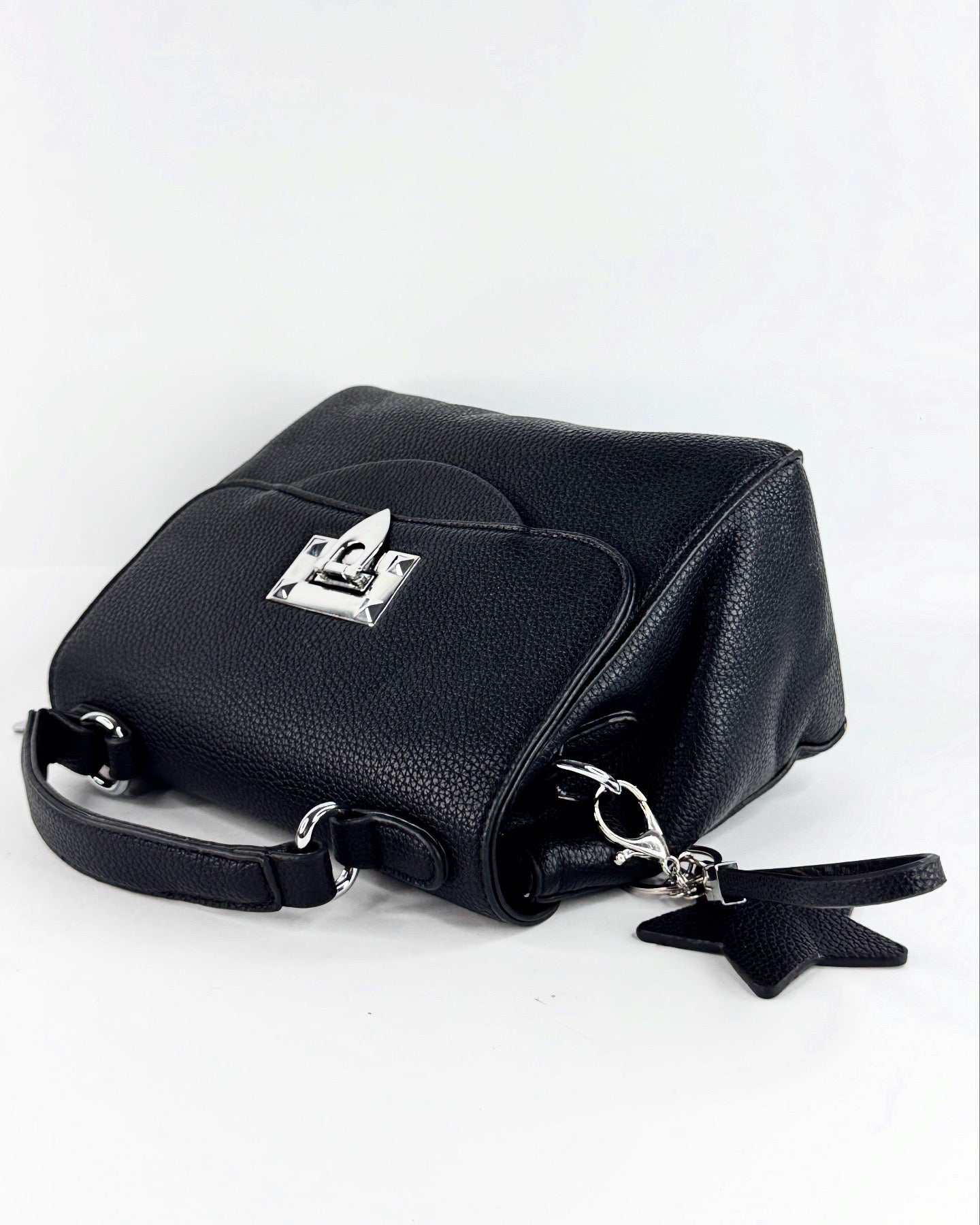 Sac à main noir élégant en cuir texturé avec poignée rigide et fermeture métallique argentée