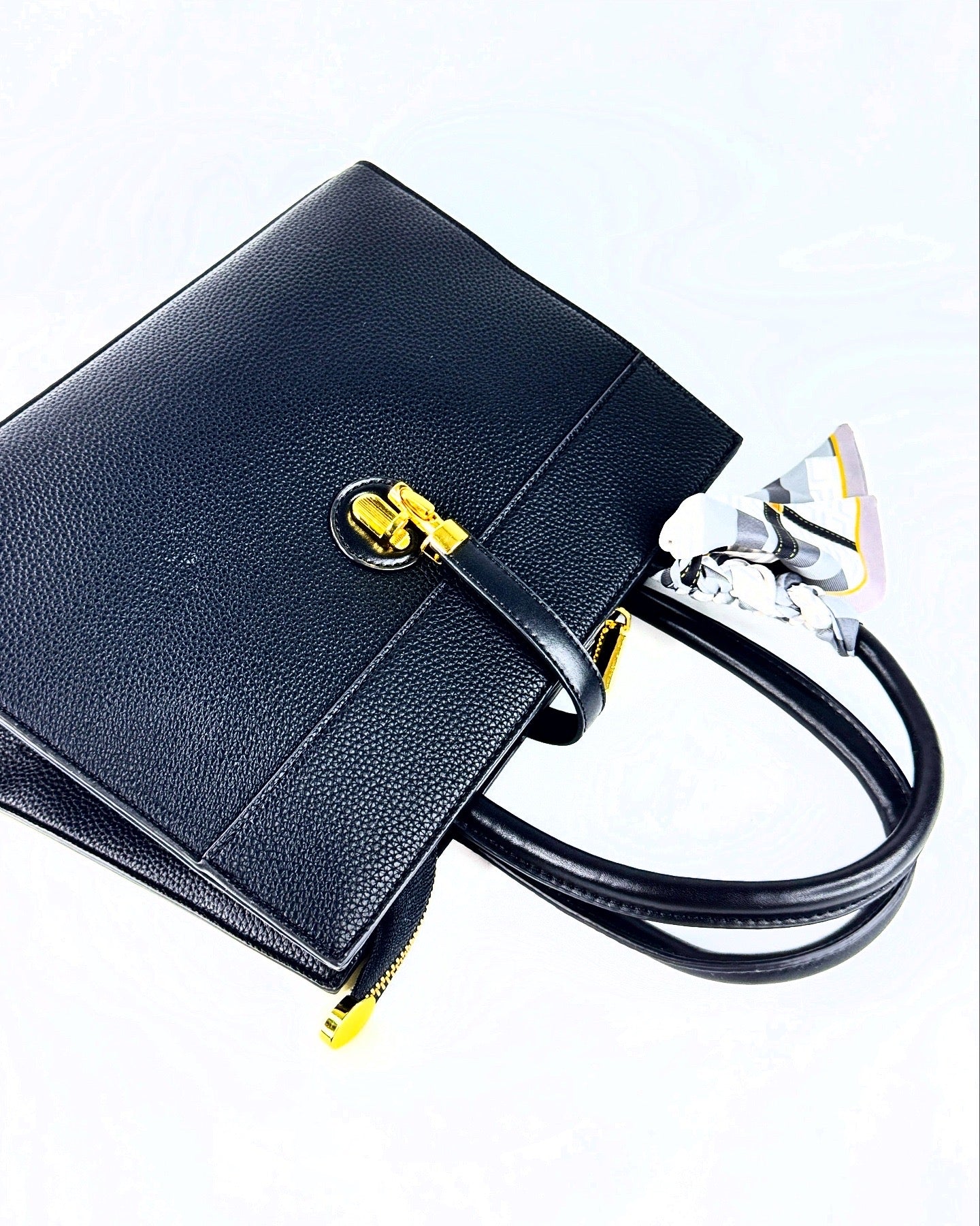 Sac à main en cuir grainé noir avec logo doré et chaîne élégante