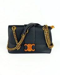 Sac en cuir grainé noir avec chaîne dorée et logo emblématique central